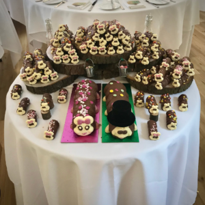 A table with Chocolate caterpillar cakes, decorated as a bride and groom, surrounded by baby caterpillar cakes- RIP willpower