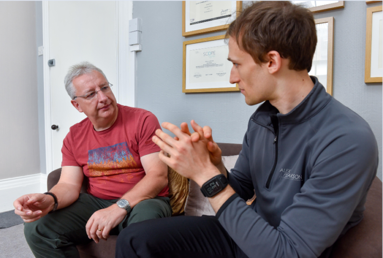 Head Coach Alex in conversation with a client at Body Matters Carlisle consulting room.
